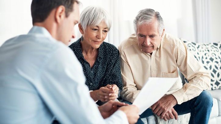 A retired couple meets with their financial advisor to go over their financial plan.