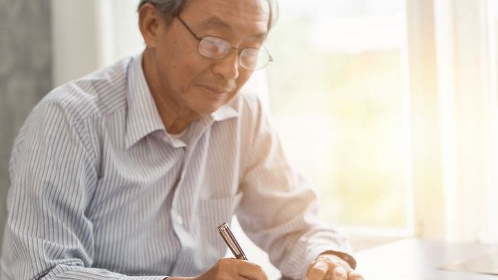 A man signs his last will and testament.