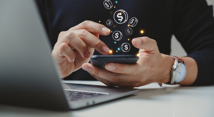 An investor uses the banking app on their phone to check their savings account.