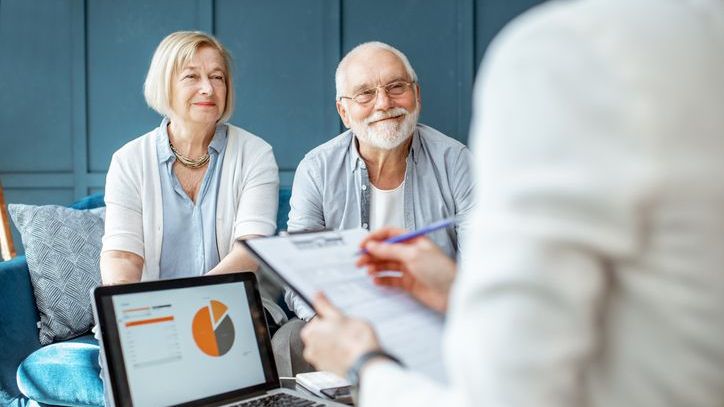 A couple meets with their financial advisor to discuss whether they're read to retire.