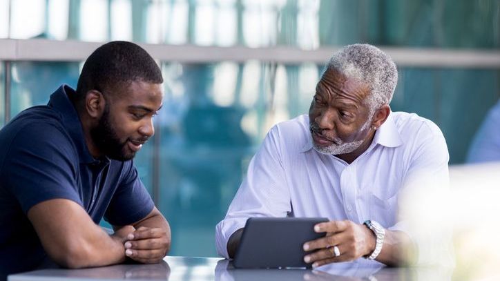 A man goes over his will with his son, who will serve as the executor of his estate.