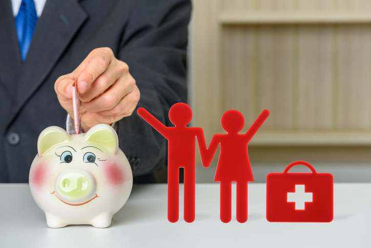 A man symbolically putting money into a piggy bank to represent funding an HSA.