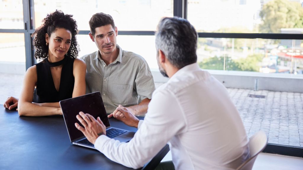 A couple meets with a wealth planner to talk about their finances.