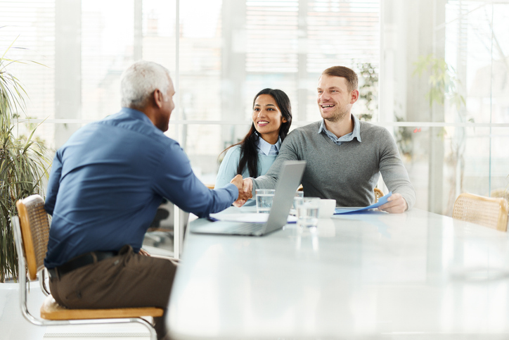 A couple reviewing their finances with a personal financial advisor.