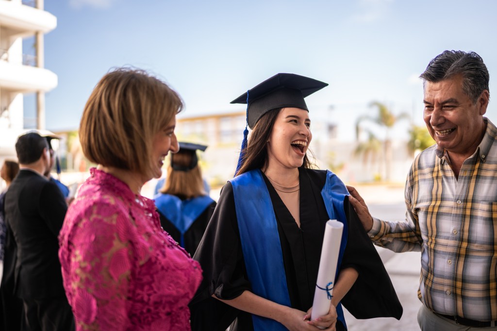 Proud parents congratulating their daughter after graduating from college.