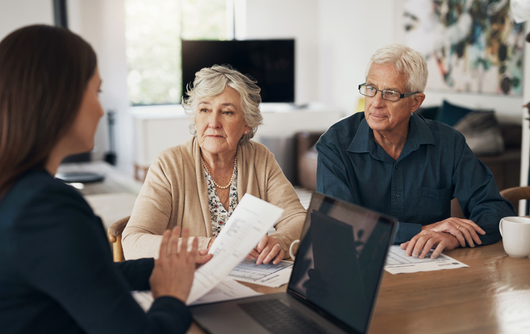 A senior couple working with a financial advisor to set up an estate plan in Minnesota.