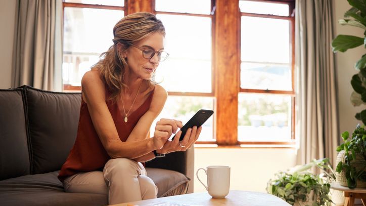 A woman reviews her investment portfolio on her phone.
