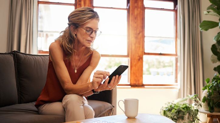 A woman looks over various 529 plans on her phone.