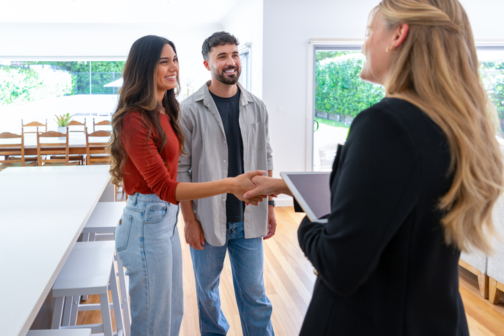 A couple touring a potential real estate investment with an agent.