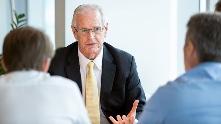 A wealth management team discusses a client's portfolio during a staff meeting.