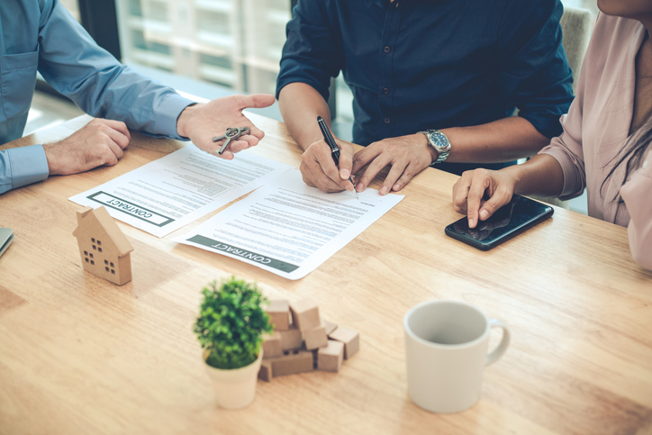 Tenants signing a lease with a landlord.