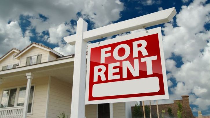 A for rent sign hangs in front of a home that a tenant placement services company is working to rent out.