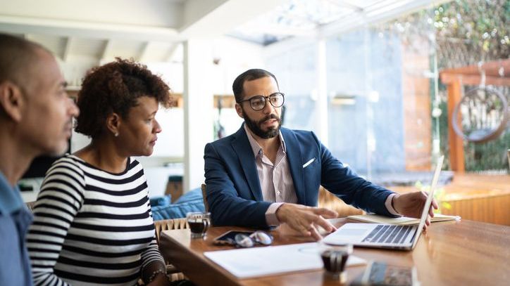 A financial advisor helps a couple evaluate several rental properties they are considering investing in.