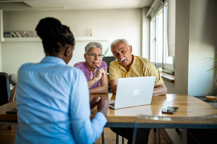 A senior couple in Texas meeting with a financial advisor to discuss adding a power of attorney to their estate plan.
