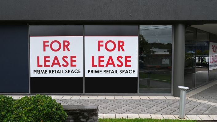 For lease signs hang in the windows of a commercial property.