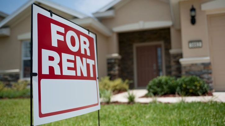 A for rent sign sits outside of a single family home owned by a real estate investor.