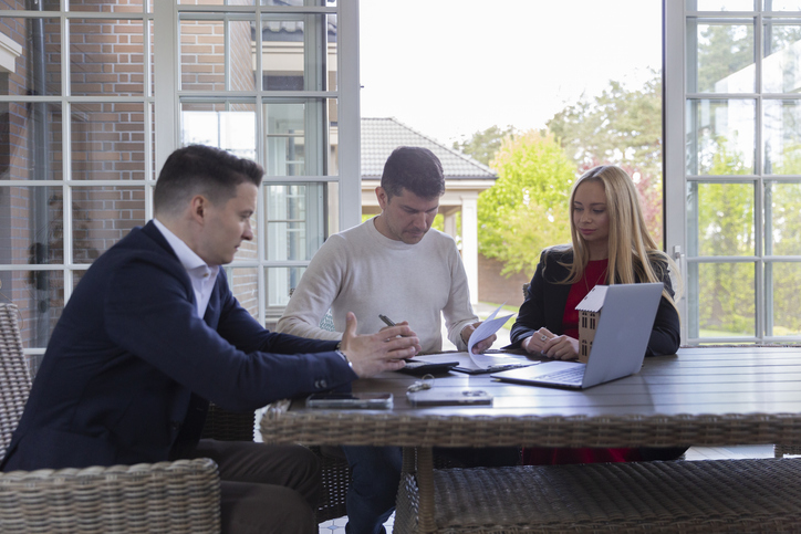 Clients meeting with a financial advisor to discuss real estate investments.