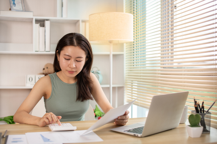 A woman calculating how much she should save for her 401(k) plan.