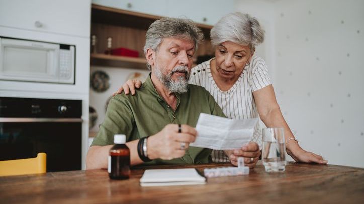 A man reviews his medical debt with his wife.