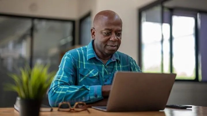 A man looks over his retirement accounts on his laptop.
