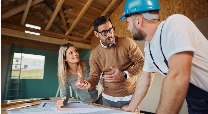House flippers talk to their contractor in a home they are flipping.