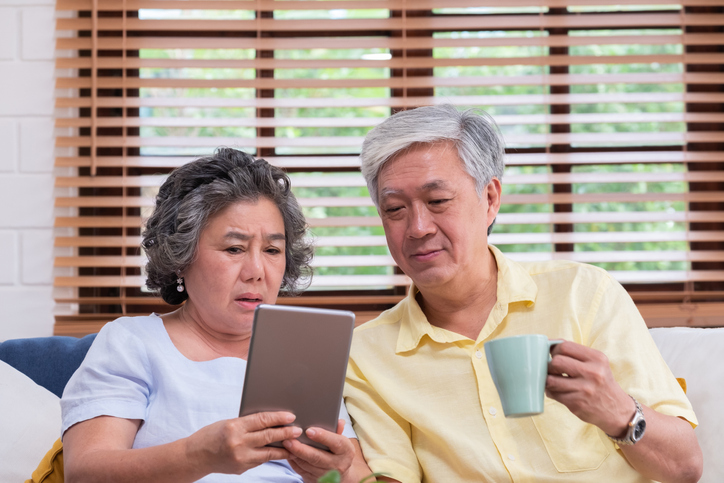 A senior couple looking up beneficiary rules based on marital status.