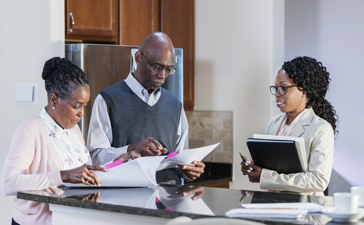 A financial advisor working with clients at their home.