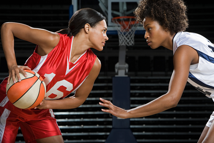 Two women face off in a basketball match.