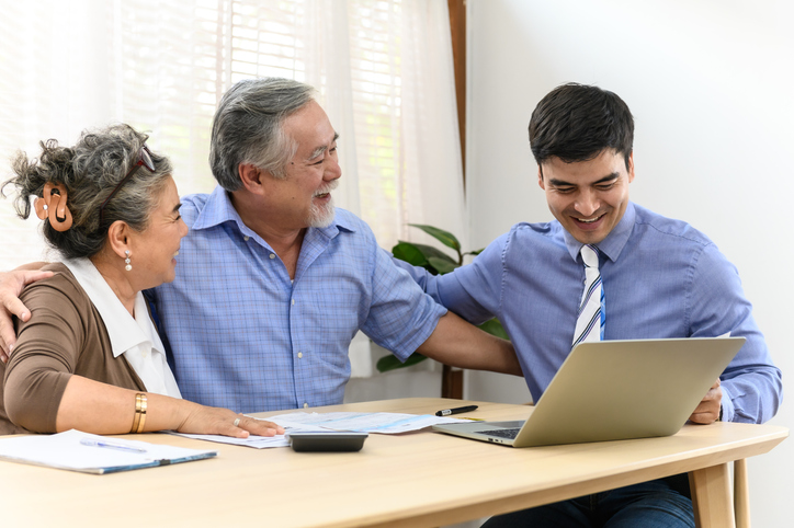 A senior couple discussing ways to invest in India's economy with a financial advisor.