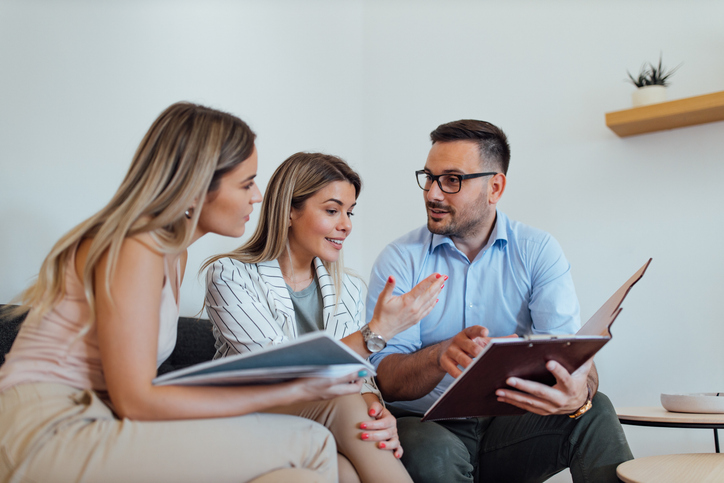 Investors meeting with a financial advisor to discuss investing in real estate ETFs.