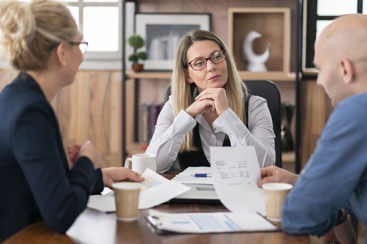 A financial advisor helping clients compare investment opportunities for preferred stock and high-yield bonds.