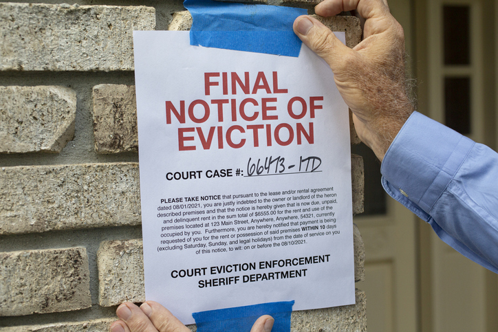 A final notice of eviction taped to the exterior of a home.