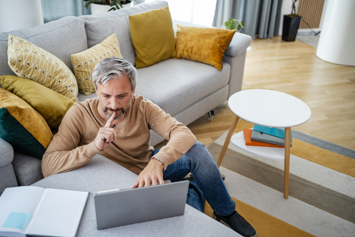A man considering whether he should refinance his mortgage to consolidate debt.