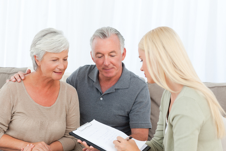 A senior couple creating an estate plan with a financial advisor.