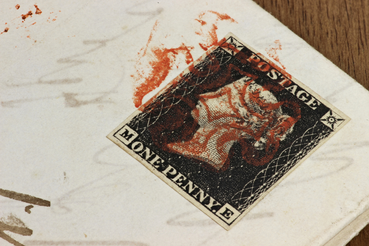 The one penny black is the world's first adhesive postage stamp, photographed with red Maltese cross cancellation on the entire wrapper.