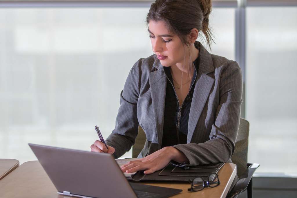A woman reviewing apps and platforms to help her get started with micro investing.