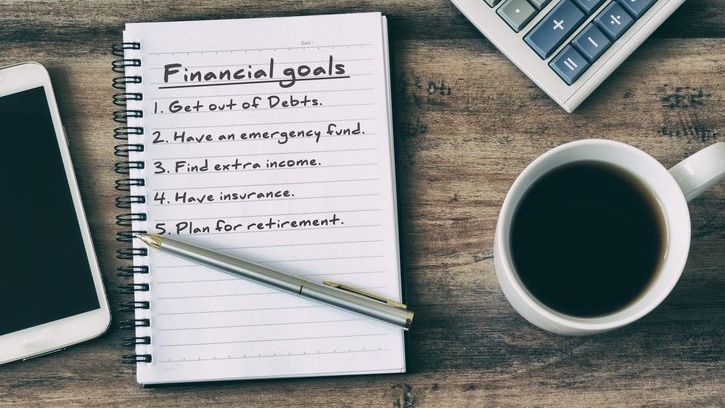 A list of financial goals on a pad of paper.