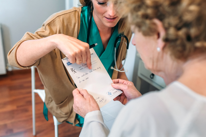 A doctor giving a prescription to senior patient.