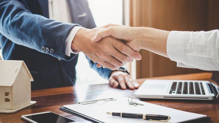 An investor shakes hands with her attorney after creating a deferred sales trust for an investment she's preparing to sell.