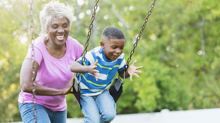 A woman who recently retired from her job as a teacher in Florida pushes her grandson in a swing.