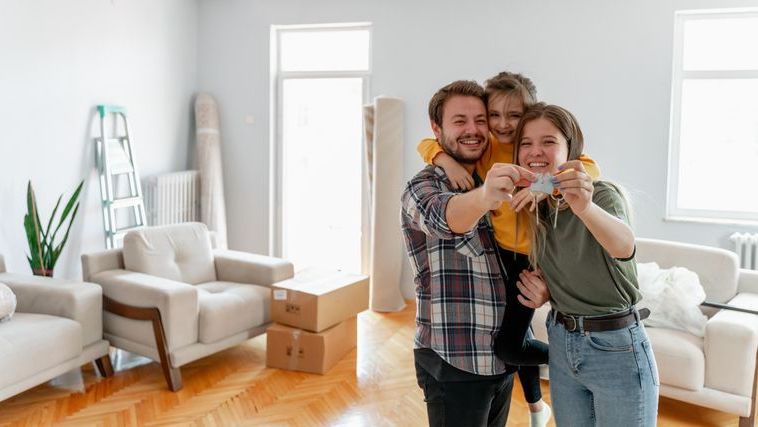 A family that bought their first home with the help of a grant celebrates inside their new living room.
