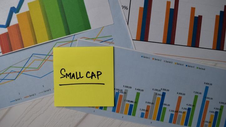 A sticky note labels graphs and charts tracking the performance of small-cap stocks.
