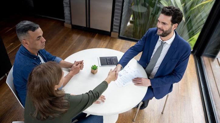 A landlord shakes hands with two of his tenants after agreeing to a tenancy-at-will arrangement.