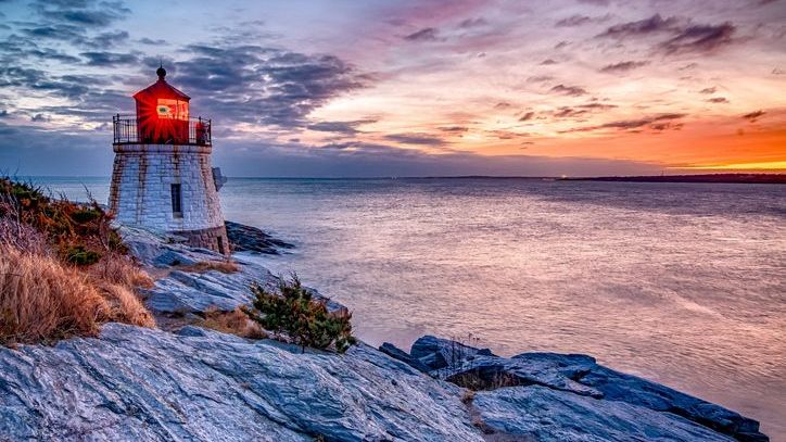 The sun sets behind the Castle Hill Lighthouse in Newport, Rhode Island.