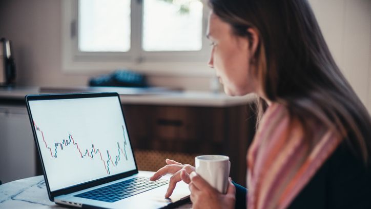 A woman sits at her kitchen table and reviews the performance of an ETF that she's considering buying.