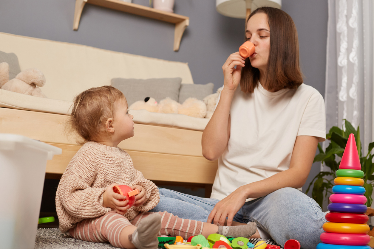 A nanny organizing different activities and playing with a toddler.