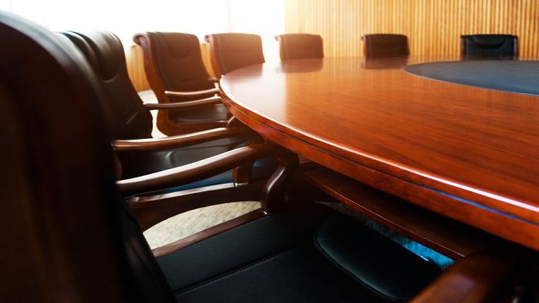 Chairs surround the table inside of a company's board room.