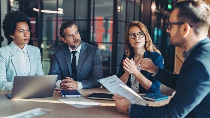 The members of a financial advisory firm's management team discuss a potential management buyout.