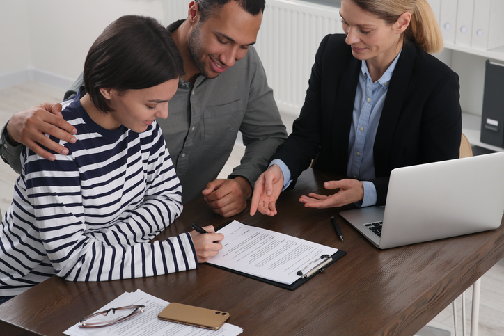 Investors updating documentation with a financial advisor for their portfolio.