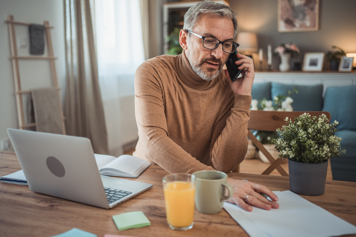An investor discussing his portfolio with a financial advisor on the phone.